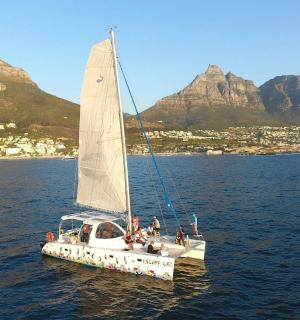 a sailboat in the water with mountains in the background