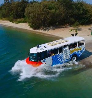 a bus in the water next to a beach