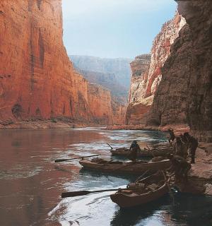 a painting of boats in a river in a canyon