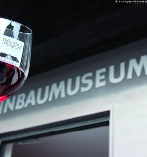 eine Person, die ein Glas Rotwein hält