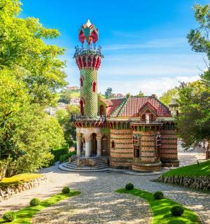 ein Haus mit einem Turm inmitten eines Gartens