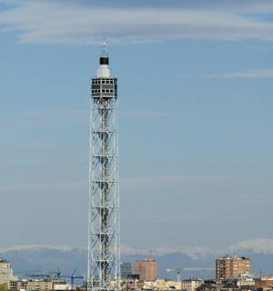 a white tower with a city in the background