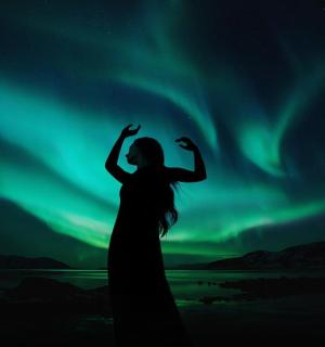 站在北极光前的一位女士