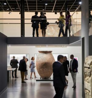一群人拿着花瓶在博物馆里走来走去