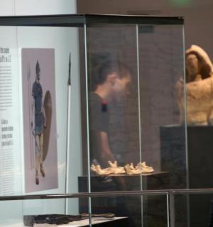 a man looking at a display case in a museum