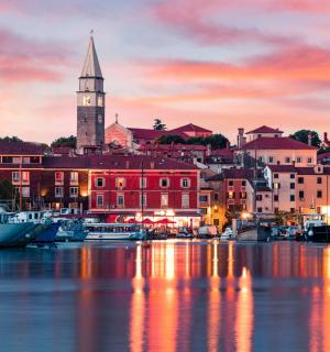 město s hodinovou věží a loděmi ve vodě