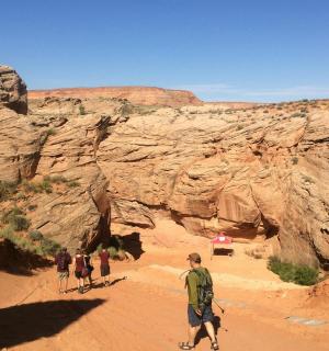 a group of people walking through a canyon