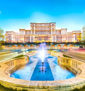 un grande edificio con una fontana di fronte a una strada