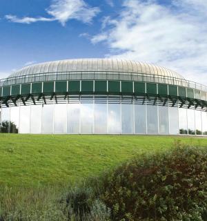 绿色田野上的一座大型玻璃建筑