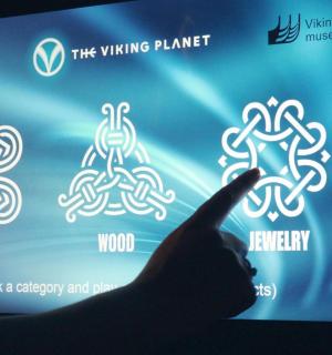 一个人的手正指向带有白色符号的屏幕