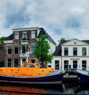 a group of boats docked in a canal with buildings