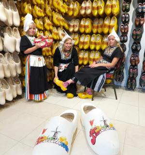 a group of three women sitting in a store with shoes