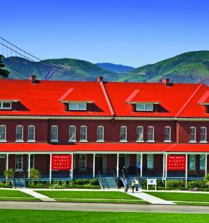 a large red building with a bridge in the background