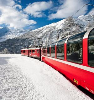 a red train on the tracks in the snow
