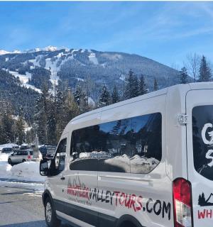 Bílá dodávka zaparkovaná na parkovišti s horou