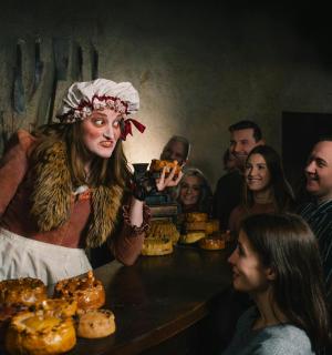 a group of people standing around a table with a woman