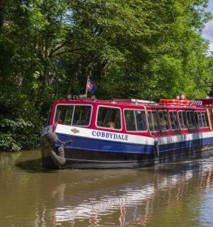 a red and white boat traveling down a river