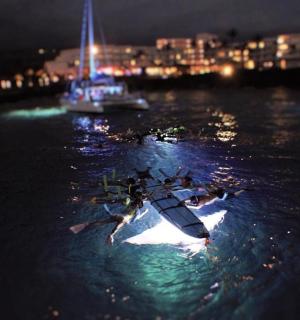 Skupina lidí v kajaku ve vodě v noci