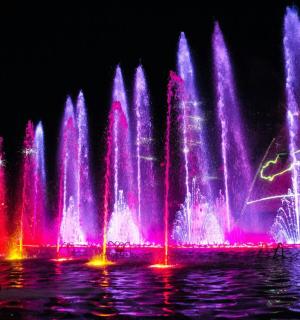 带有粉色和紫色灯光的大型喷泉