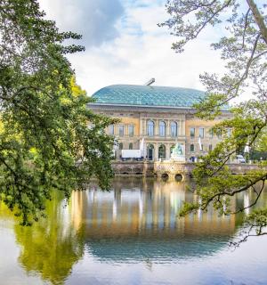 a building in the middle of a lake with trees