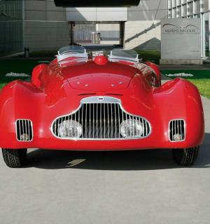 一辆红色汽车停在一栋建筑物前