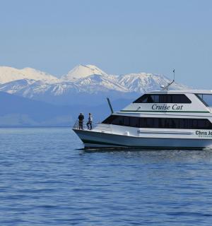 a boat on the water with mountains in the background