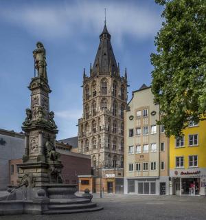 en statue foran en bygning med et tårn