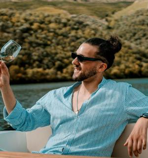 a man sitting on a boat holding a glass of wine