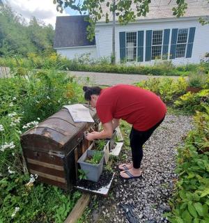a person bending over a box in a yard