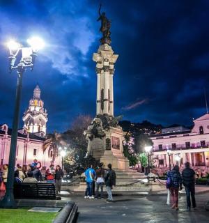 一群人站在城市里的一座雕像周围