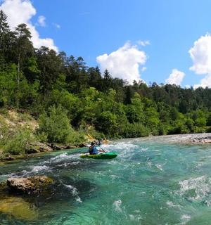 osoba jedoucí na voru v řece