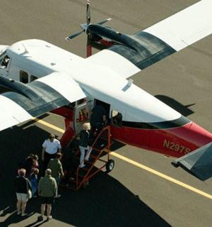 a group of people standing around a small plane