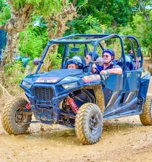 a group of people riding in a toy vehicle in the mud