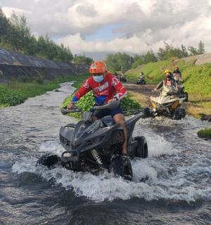 一名男子骑着四轮车过河