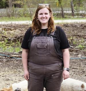 a woman is standing next to two sheep