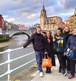 skupina lidí stojící před mostem