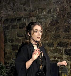 a woman standing in front of a brick wall