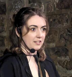 a woman standing in front of a brick wall