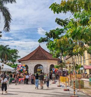 a group of people walking around a market with a building