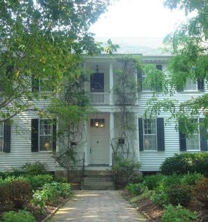 ένα λευκό σπίτι με μια άσπρη πόρτα και δέντρα