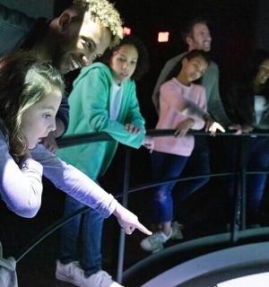 skupina lidí sledujících muže a malou dívku