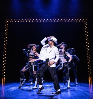 skupina lidí sedících na židlích na pódiu