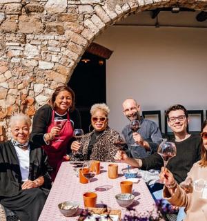 一群人坐在桌边，手里拿着酒杯