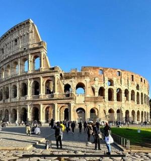 a group of people standing in front of the coliseum