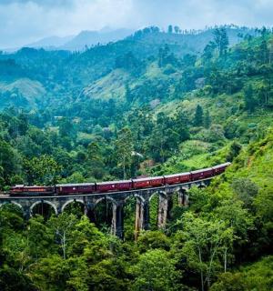 a train on a bridge in the mountains