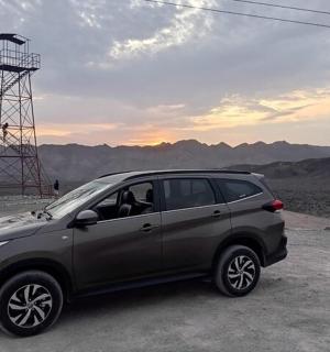 a car parked in front of a tower in the desert