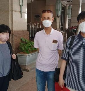 一群戴着口罩的人在一栋建筑里