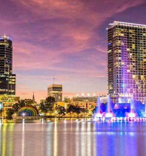 a city skyline with tall buildings and a fountain