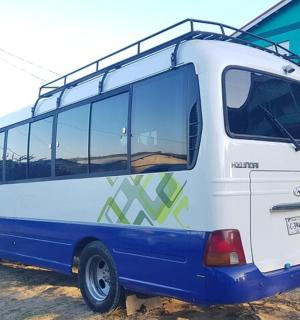 a blue and white bus parked in front of a building