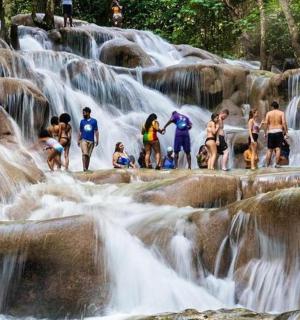 a group of people standing in front of a waterfall